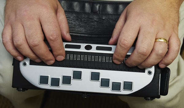 Close-up of Seth's hands on the Braille machine